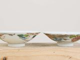 pair of chinese porcelain bowls on a wooden stand on a white background