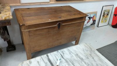 a wooden chest sitting in a room with pictures on the wall