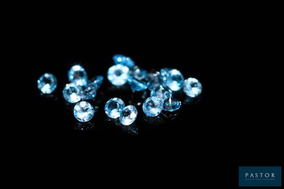 un gros plan sur un bouquet de diamants bleus posés sur une surface noire