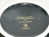 a black and white plate with gold writing on it