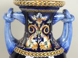 a blue and yellow vase sitting on a table