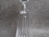 flacon de parfum en verre transparent muni d'un bouchon en verre, sur fond gris