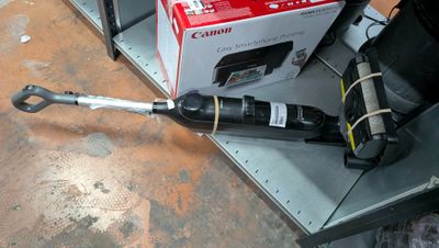 une bouteille de vin posée sur une étagère à côté d'une paire de ciseaux