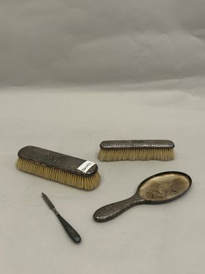 three brushes and a comb sitting on a white surface