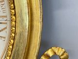 a gold clock with roman numerals on the face of it