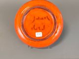 an orange plate with a smiley face on it