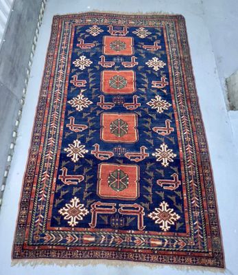 un tapis posé à même le sol dans une pièce aux murs blancs