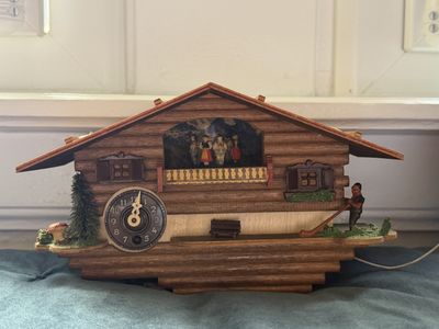une horloge à coucou en bois posée sur une table sur laquelle se trouve une horloge