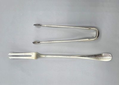 three forks and spoons sitting on top of a white surface