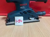 un gros plan d'une ponceuse posée sur une table, avec une étiquette de prix