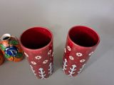 two red vases sitting next to each other on a table