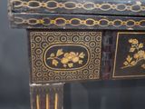 a black and gold table with a drawer on it