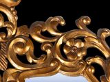 a mirror that has a gold frame with a bird on it