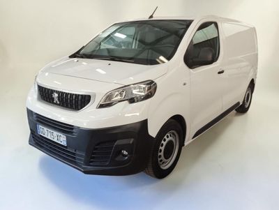 La camionnette blanche est garée sur le sol blanc de la pièce.