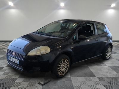 la photo d'une petite voiture noire garée sur un sol en damier