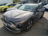 the front end of a gray car parked in a lot