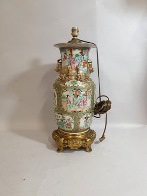 une lampe posée sur une table à côté d'un vase