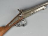 un vieux pistolet avec une poignée en bois sur une surface blanche