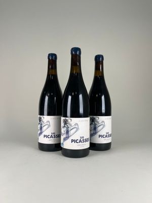 trois bouteilles de vin posées sur une table l'une à côté de l'autre