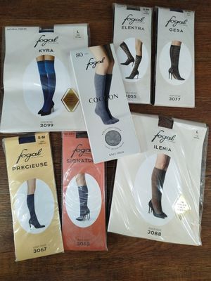 Plusieurs paires de chaussettes montant jusqu'aux genoux sont posées sur une table.