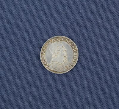 un gros plan d'une pièce d'argent posée sur un tissu bleu