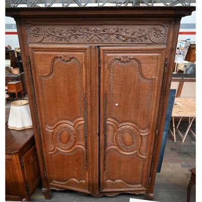 une grande armoire en bois ornée de sculptures en haut et en bas