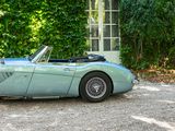 a blue sports car parked in front of a house