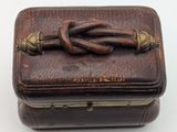an old leather box with a knot on the top of it