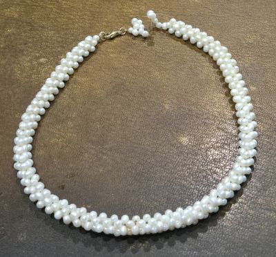 a close up of a white pearl necklace on a table