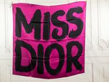 pink and black miss dior banner hanging from a white wall