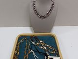 a tray with a necklace, bracelets, and a necklace on it