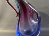 un vase en verre bleu et violet posé sur une table