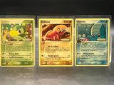 three pokemon cards sitting on top of a table next to each other