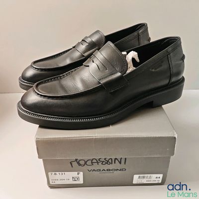 une paire de chaussures noires posée sur une boîte