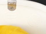 someone is holding a white bag with a yellow shirt on it