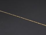 a close up of a gold chain on a black surface