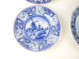 three blue and white plates on a white table