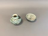 a small vase and a small bowl sitting on a table