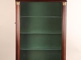 an antique display cabinet with a green glass door and gold trimming