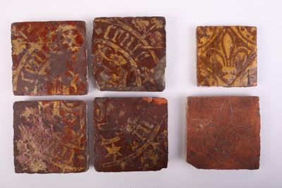 four pieces of red and brown clay with designs on them