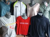several mannequins of different colors and sizes of shirts in a storage area