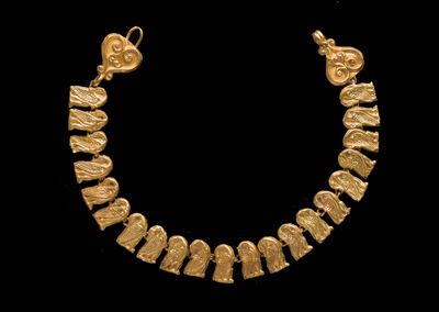 gros plan d'un collier en or sur fond noir
