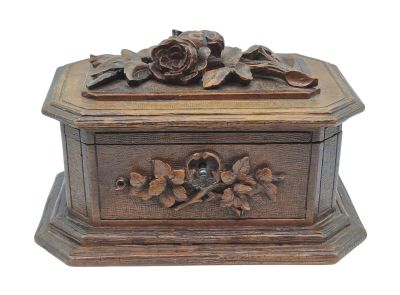 boîte en bois sculptée, ornée de fleurs et de feuilles sur fond blanc