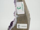 a stone with a tag on it that is sitting on a white surface