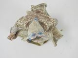 a small figurine of a fish on a white surface