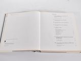 an open book on a white table with a pen and paper