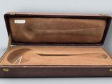 a brown case with a pair of scissors inside of it