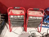 two red portable heaters sitting on a white table