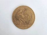 a gold coin with a rooster on it on a white surface