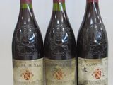 three bottles of wine are lined up on a white surface